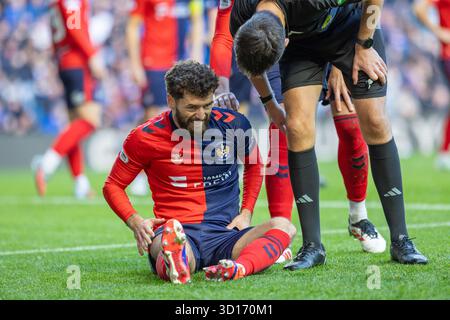 26 ottobre 2025. Glasgow, Regno Unito. I Rangers FC hanno giocato il Kilmarnock FC all'Ibrox Stadium, lo stadio casalingo dei Rangers, in una partita di football della William Hill Premiership. Il punteggio finale è stato Rangers 3 - 1 Kilmarnock. Jamie Brandon (K2) siede a terra sostenendo di essere stato ferito ed è controllato da Kevin Clancy, l'arbitro. Crediti: Findlay/ Alamy Live News Foto Stock