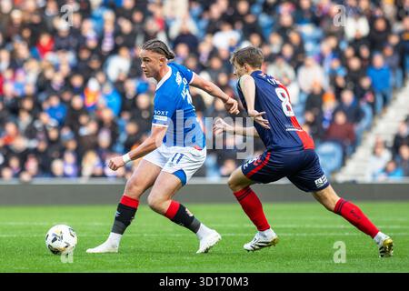 26 ottobre 2025. Glasgow, Regno Unito. I Rangers FC hanno giocato il Kilmarnock FC all'Ibrox Stadium, lo stadio casalingo dei Rangers, in una partita di football della William Hill Premiership. Il punteggio finale è stato Rangers 3 - 1 Kilmarnock. Thelo Aasgaard (R11) sfugge Brad Lyons (K8) crediti: Findlay/ Alamy Live News Foto Stock