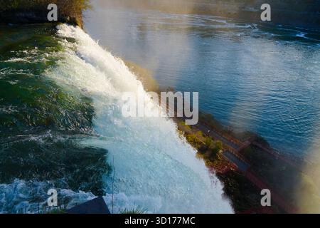 Un'ampia vista dal bordo delle American Falls al Niagara Falls State Park che mostra l'acqua a cascata, il fiume sottostante e la piattaforma di osservazione Foto Stock