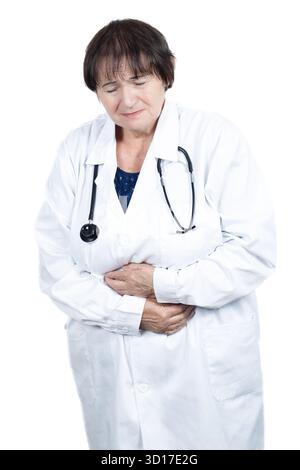 Medico anziano in camice bianco tiene le mani sopra l'addome, soffia di mal di stomaco o disturbi gastrointestinali durante la clinica Foto Stock