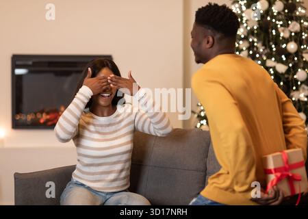 Il fidanzato sorprende la moglie con Gift for Valentine Celebration indoor Foto Stock
