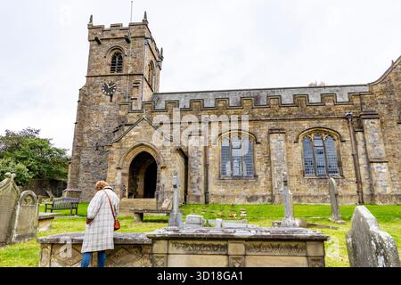 Downham Village, Lancashire, Inghilterra, modella rilasciata nel cimitero della chiesa di St Leonards tra le lapidi, Regno Unito Foto Stock