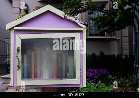 Biblioteca pubblica gratuita con scambio di libri alloggiata in un piccolo rifugio di legno montato su un palo di legno su un marciapiede a Toronto, Ontario, Canada. Foto Stock