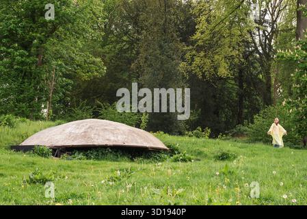 C'è qualcosa di strano nella foresta. Un bambino vede una strana forma mentre cammina nel bosco. UFO o fungo gigante Foto Stock