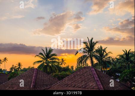Tramonto sui tetti tradizionali di Senggigi, Lombok, Indonesia Foto Stock