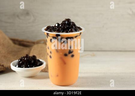 Tè al latte tailandese freddo con perla di Boba o tè Thai Bubble in Plastic To Go Cup su sfondo bianco Foto Stock