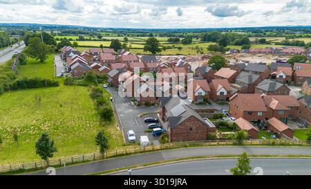 Vista aerea del villaggio di Cotchett, Mickleover, Derby, mostrando nuove case circondate da campi verdi nel South Derbyshire. Foto Stock
