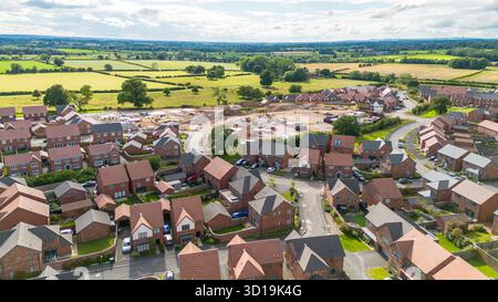Vista aerea del villaggio di Cotchett, Mickleover, Derby, mostrando nuove case e la costruzione di abitazioni in corso nel South Derbyshire. Foto Stock