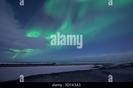Vista dell'eterea aurora boreale danzare attraverso il cielo invernale, illuminando il paesaggio frigido di Jokulsarlon, Sveitarfélagið Hornafjörður, Islanda. Foto Stock