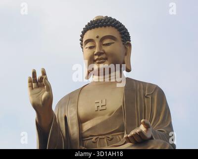 Kaohsiung, Taiwan - 11 novembre 2024: Un intimo ritratto ravvicinato del gigante Fo Guang Big Buddha seduto, che mostra il gesto della mano e la tranquilla facciata Foto Stock
