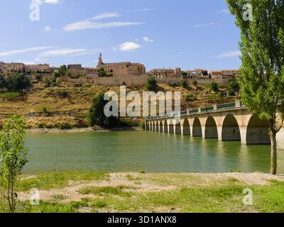 Antico villaggio su una collina circondata dal fiume con un ponte sull'acqua Foto Stock