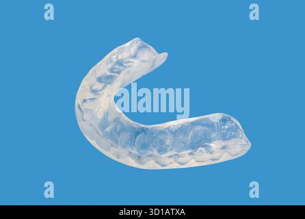 Primo piano di staffe cosmetiche ortodontiche invisibili su sfondo blu. Allineatori dei denti per un sorriso stupendo. Foto Stock