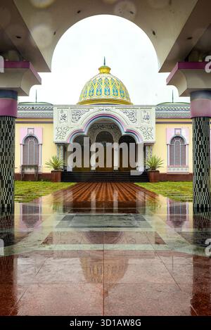 Ingresso alla Moschea colorata con tetto a cupola, calligrafia araba e pavimento bagnato riflettente Foto Stock