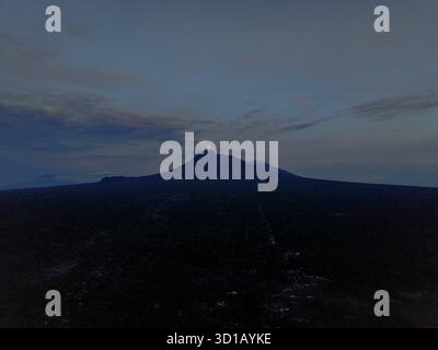 Vista aerea del Monte Merapi contro la luce del giorno, una maestosa silhouette che domina l'orizzonte, Klaten, Giava centrale, Indonesia. Foto Stock