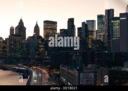 Vista di un vivace skyline che abbellisce di luce dorata, riflettendo i moderni grattacieli e le strade tortuose al crepuscolo, New York, New York, Stati Uniti. Foto Stock