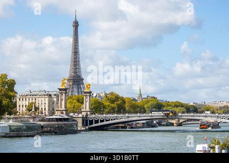 Vista della Torre Eiffel che perfora lo skyline, riflessa nelle acque scintillanti della Senna, con il ponte ornato Pont Alexandre III, Parigi, Ile-de-FR Foto Stock