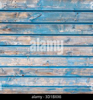 vecchia recinzione in legno grintoso con vernice blu sbucciata su assi orizzontali formano un modello astratto Foto Stock