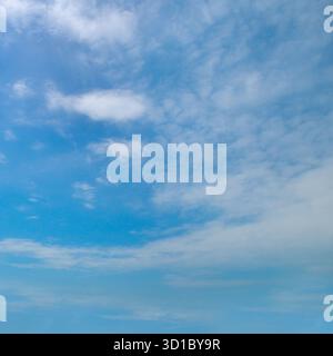 Un cielo azzurro ampio e luminoso pieno di nuvole bianche, ideale per l'uso come sfondo o texture. Foto Stock