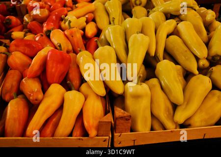 Peperoni rossi e gialli colorati in casse di legno al mercato. Concetto di cibo biologico, freschezza e dieta vegetariana. Foto Stock