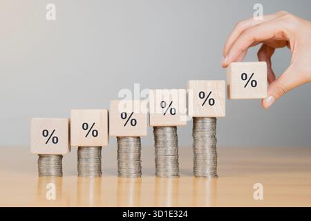 Concetto di crescita del business finanziario. L'imprenditore calcola il reddito e gli utili sugli investimenti e una percentuale di aumento sulle pile di monete. Foto Stock