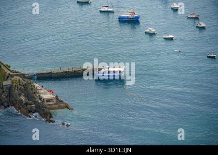 Vista ad alto angolo delle barche ormeggiate vicino al molo dell'isola di Santa Clara nella baia di la Concha, Donostia, Spagna Foto Stock