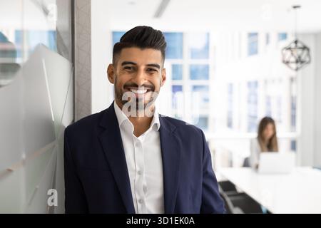 Felice uomo d'affari indiano che posa per il ritratto professionale Foto Stock