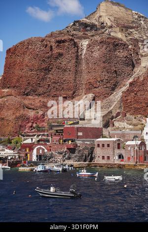 Amoudy Bay Red Volcanic Cliffs - pesca barche e ristoranti nel Mar Egeo - Santorini Island, Grecia Foto Stock