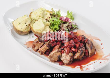 Fette di manzo arrosto con salsa di bacche, mele e pera, patate e insalata verde Foto Stock
