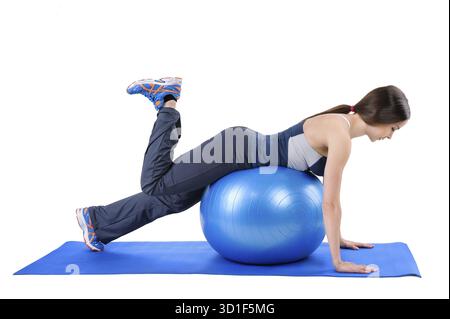 Young Woman mostra la posizione di partenza dell'allenamento fitness Stability Ball Glute Kickback, isolato sul bianco Foto Stock