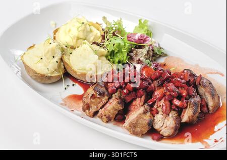 Fette di manzo arrosto con salsa di bacche, mele e pera, patate e insalata verde Foto Stock