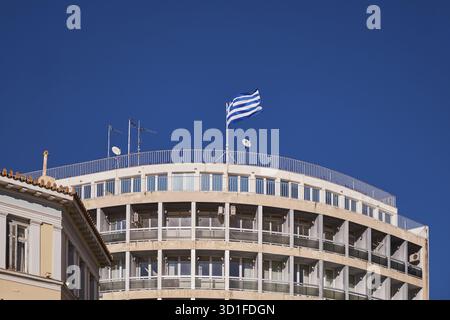 Edificio moderno con balconi e una bandiera greca in cima - Atene, Grecia Foto Stock