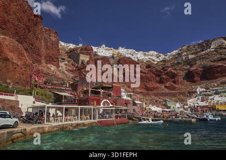 Amoudy Bay Red Volcanic Cliffs - pesca barche e ristoranti nel Mar Egeo - Santorini Island, Grecia Foto Stock