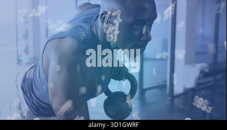 Uomo in abbigliamento sportivo che esegue una fila di kettlebell a un braccio nella zona pesi della palestra, con portapacchi e barre, asciugamano Foto Stock