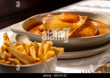 Il Francesinha Especial' tradizionale del Portogallo settentrionale, consiste di strati di pane, carni assortite e formaggio fuso. Foto Stock