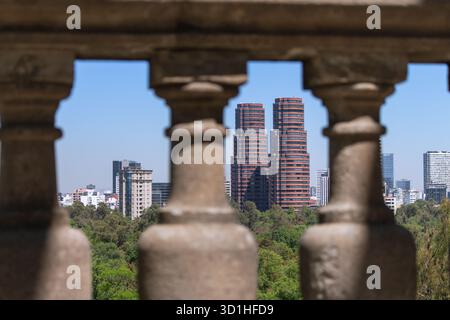 Le moderne torri gemelle rosse si vedono attraverso la storica balaustra in pietra nello skyline di città del Messico, ricavata dal castello di Chapultepec Foto Stock