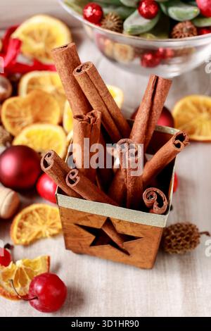 Decorazioni natalizie tradizionali: Bastoncini di cannella, frutta secca e palle. Foto Stock
