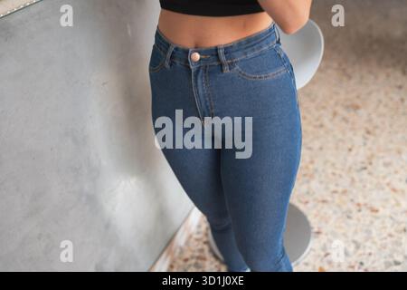 Una giovane donna rilassata si diverte con un delizioso latte macchiato in un caffè con una vibrazione informale Foto Stock