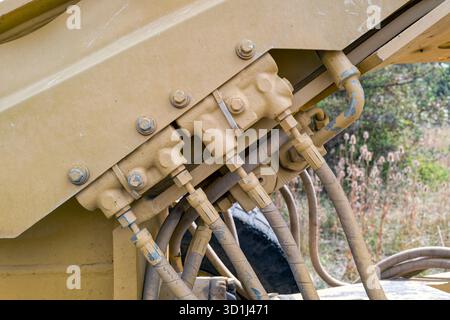 Il dettaglio del complessivo connettore del tubo flessibile sulla parte esterna di un motorgrader Foto Stock