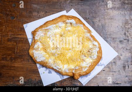 Il Lángos è una tradizionale focaccia ungherese fritta fatta con un impasto lievitato, fritto in profondità fino a quando non dorato e croccante. Foto Stock