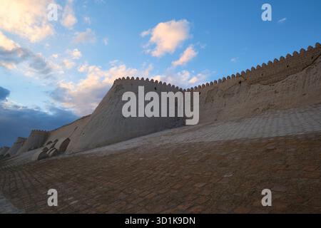 Vista pomeridiana di un bastione. Lungo il fango, parete perimetrale di paglia. Vista esterna della città murata, sezione di Ichan Kala di Khiva, Uzbekistan. Foto Stock