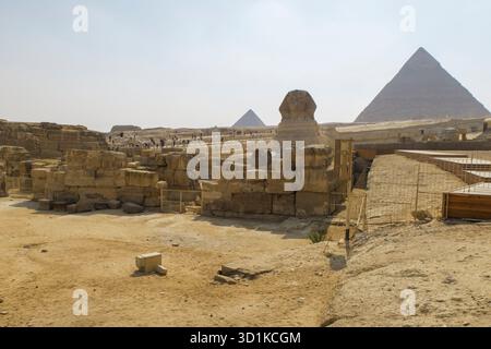Turisti che esplorano la grande Sfinge e le Piramidi di Giza sotto un cielo limpido in un sito archeologico storico in Egitto Foto Stock
