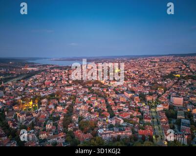 Vista panoramica della città di Varna, paesaggio urbano della Bulgaria, vista aerea con drone sullo skyline della città durante la drammatica alba Foto Stock