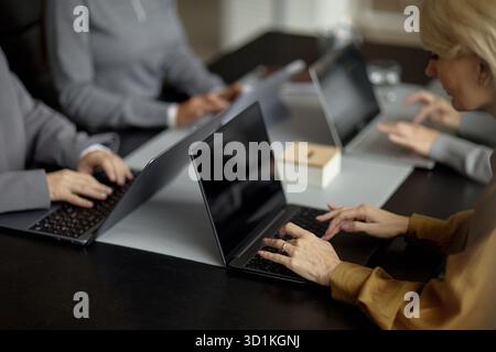 Gruppo di donne di mezza età che collaborano ai notebook in ufficio Foto Stock