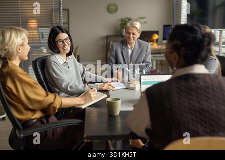 Gruppo di donne caucasiche e nere di mezza età che collaborano a Office Meeting Foto Stock