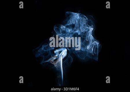 Fumo di vapore curvo caldo blu isolato su sfondo nero. Sfondo astratto, elemento di design, per sovrapporre le immagini. Crea una foto mistica di Halloween Foto Stock