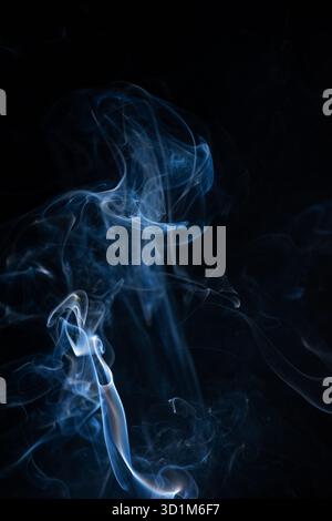 Fumo di vapore curvo caldo blu isolato su sfondo nero. Sfondo astratto, elemento di design, per sovrapporre le immagini. Crea una foto mistica di Halloween Foto Stock
