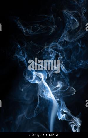 Fumo di vapore curvo caldo blu isolato su sfondo nero. Sfondo astratto, elemento di design, per sovrapporre le immagini. Crea una foto mistica di Halloween Foto Stock