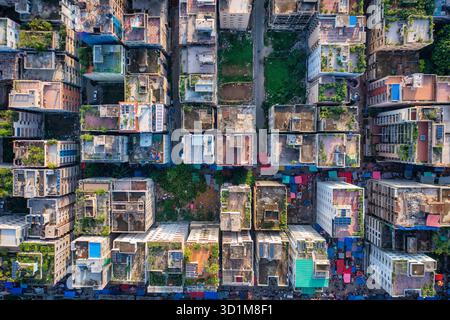 Vista aerea di edifici densamente pieni con tetti di varie texture e colori, accostati ai vivaci mercati di strada sottostanti, Dacca e Dacca Divisi Foto Stock
