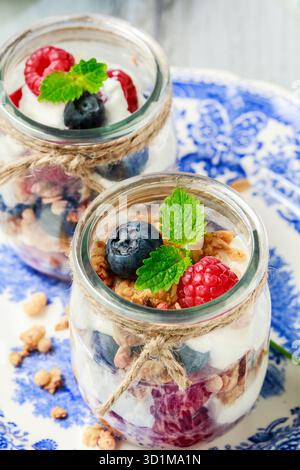 Vasetti in vetro con frutta e panna montata. Gustoso dessert estivo. Foto Stock