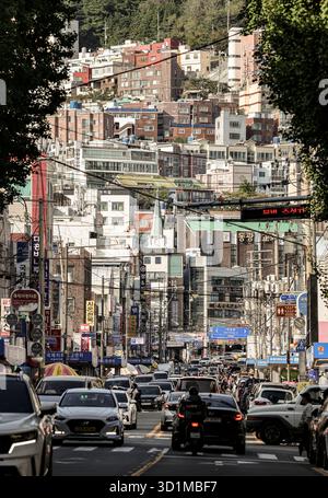 BUSAN, COREA DEL SUD - 9 OTTOBRE 2025 - Busan Street piena di auto ed edifici che salgono su una ripida collina Foto Stock